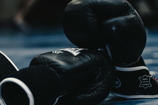 Boxing gloves resting on the mat of a ring