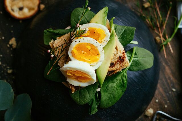 A plate of eggs, avocado and greens