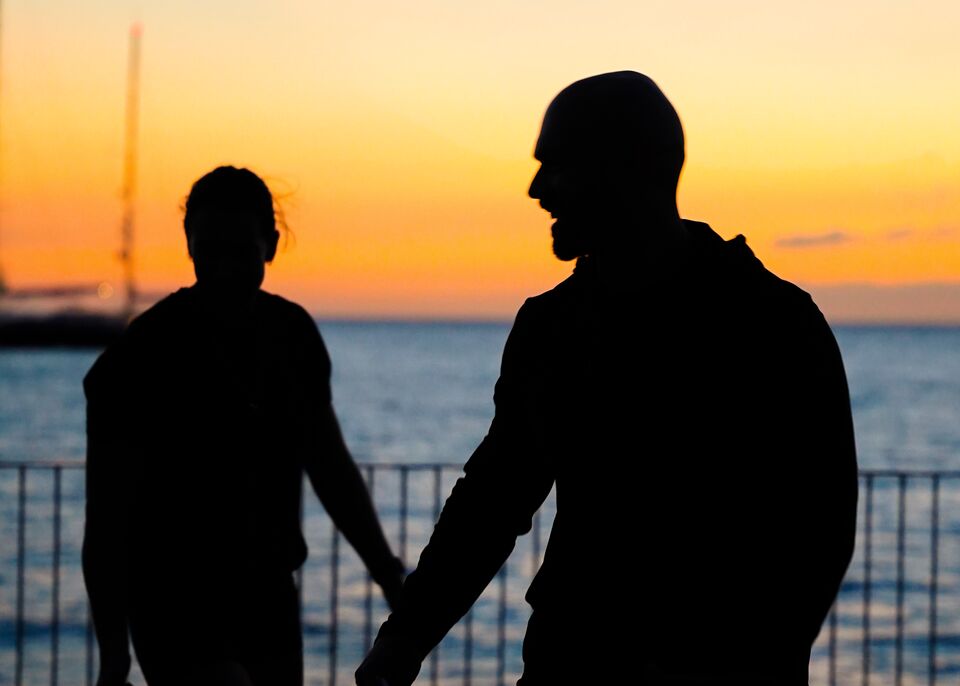 Coach and client in silhouette on the seafront at sunset