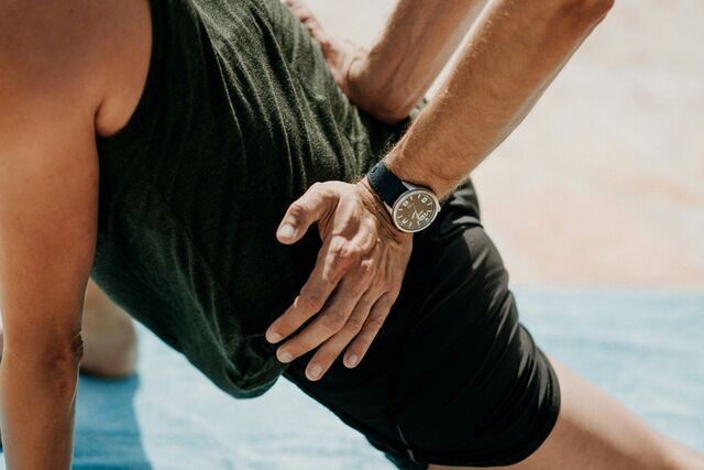 A physiotherapist's hands on a client's lower back