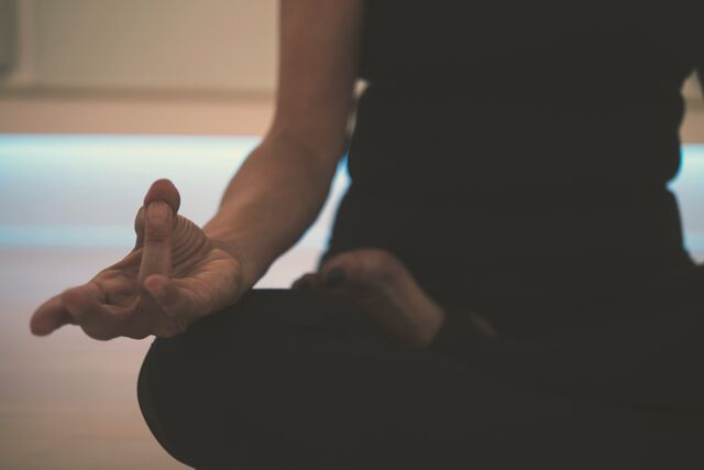 A seated meditation pose in a calm studio